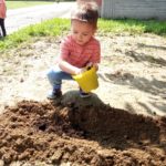 bambina che ricopre i semi con la terra