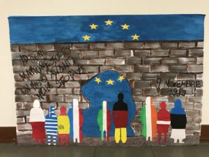 lavoro svolto dalla classe terza a rappresenta il muro con in primo piano sagome di persone i cui abiti riprendono i colori delle bandiere dei vari stati europei