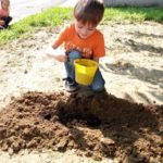 bambino che ricopre i semi con la terra