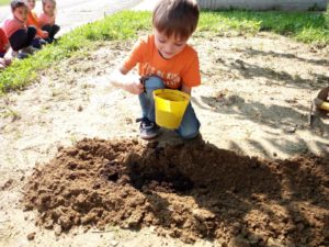 bambino che ricopre i semi con la terra