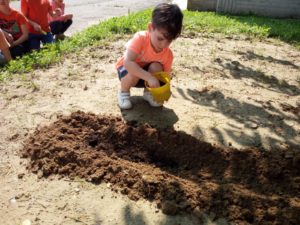 bambino che sparge la terra